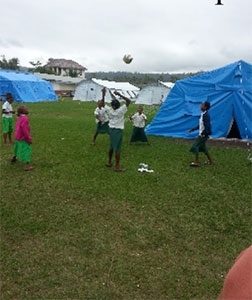 School children playing outside tent classrooms